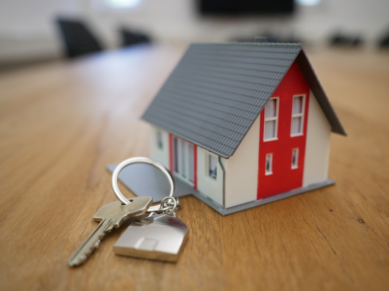 Miniature house model with keys representing real estate website and SaaS platform development.